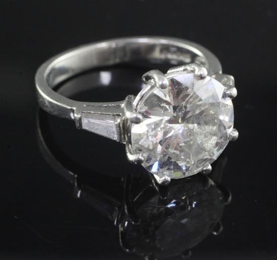 An attractive modern platinum and single stone diamond ring with trapeze cut diamond set shoulders, size K.
